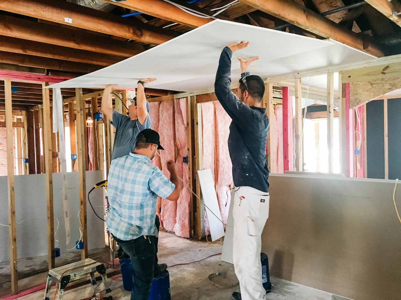 James, Jarrod, and Augustin installing drywall to the ceiling in Josh's home