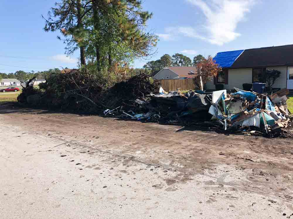 Debris piles from a flooded home